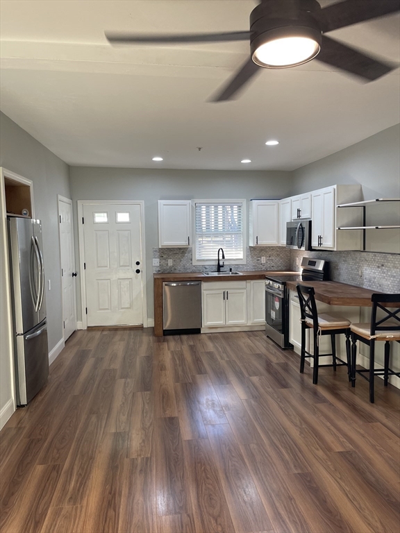 131 Stewart Street, Unit 2 Fall River, MA 02720 - Photo 3 of 16 a kitchen with stainless steel appliances kitchen island granite countertop wooden floors and cabinets