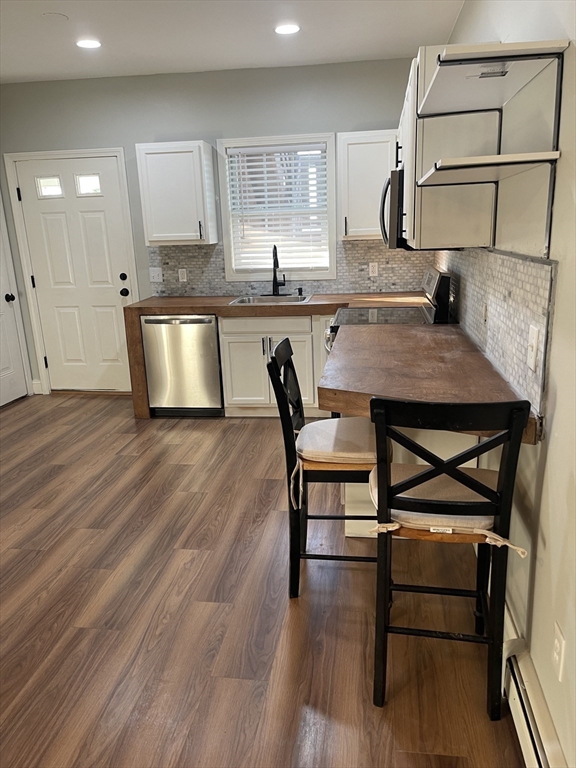 131 Stewart Street, Unit 2 Fall River, MA 02720 - Photo 5 of 16 a kitchen with a table chairs refrigerator and microwave