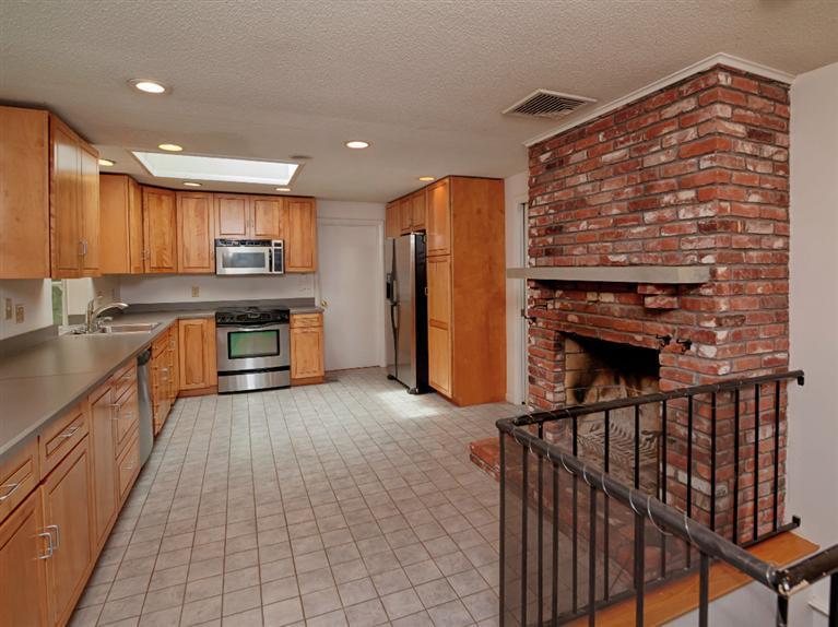 288 Huckins Neck Road Centerville, MA 02601 - Photo 5 of 18 a kitchen with stainless steel appliances granite countertop a refrigerator a stove and a sink with wooden cabinets