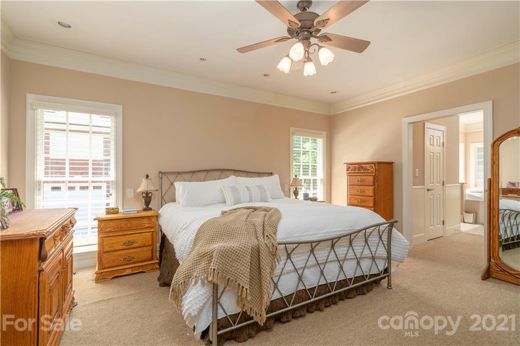 6607 Fox Ridge Circle Davidson, NC 28036 - Photo 23 of 48 a bedroom with a bed and a chandelier