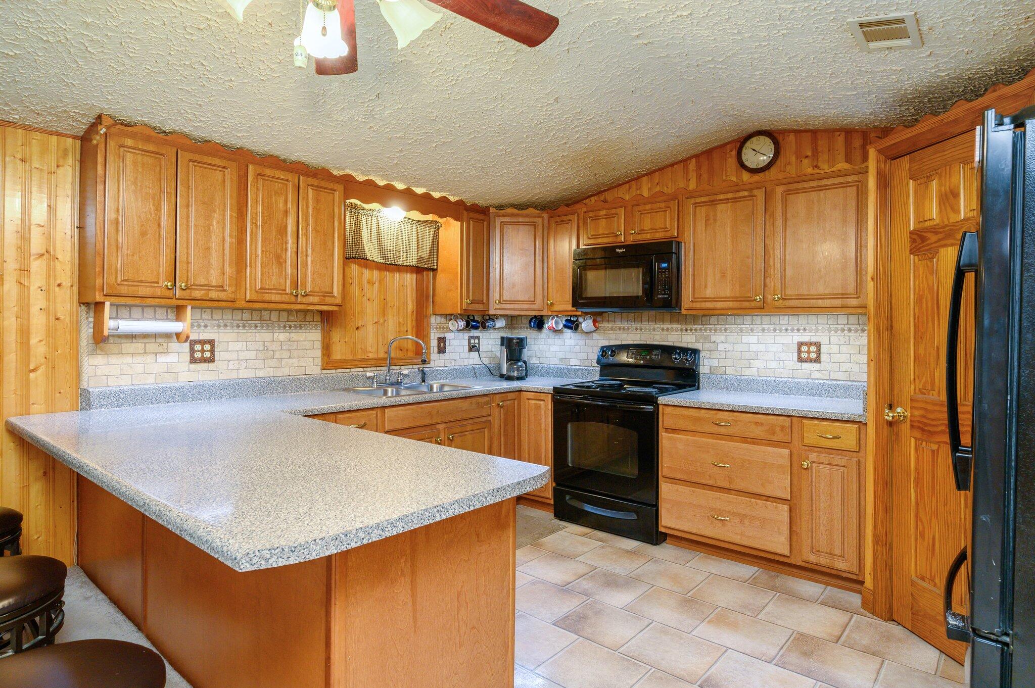 52 Tulip Avenue DeFuniak Springs, FL 32433 - Photo 18 of 34 a kitchen with stainless steel appliances a stove sink microwave and cabinets