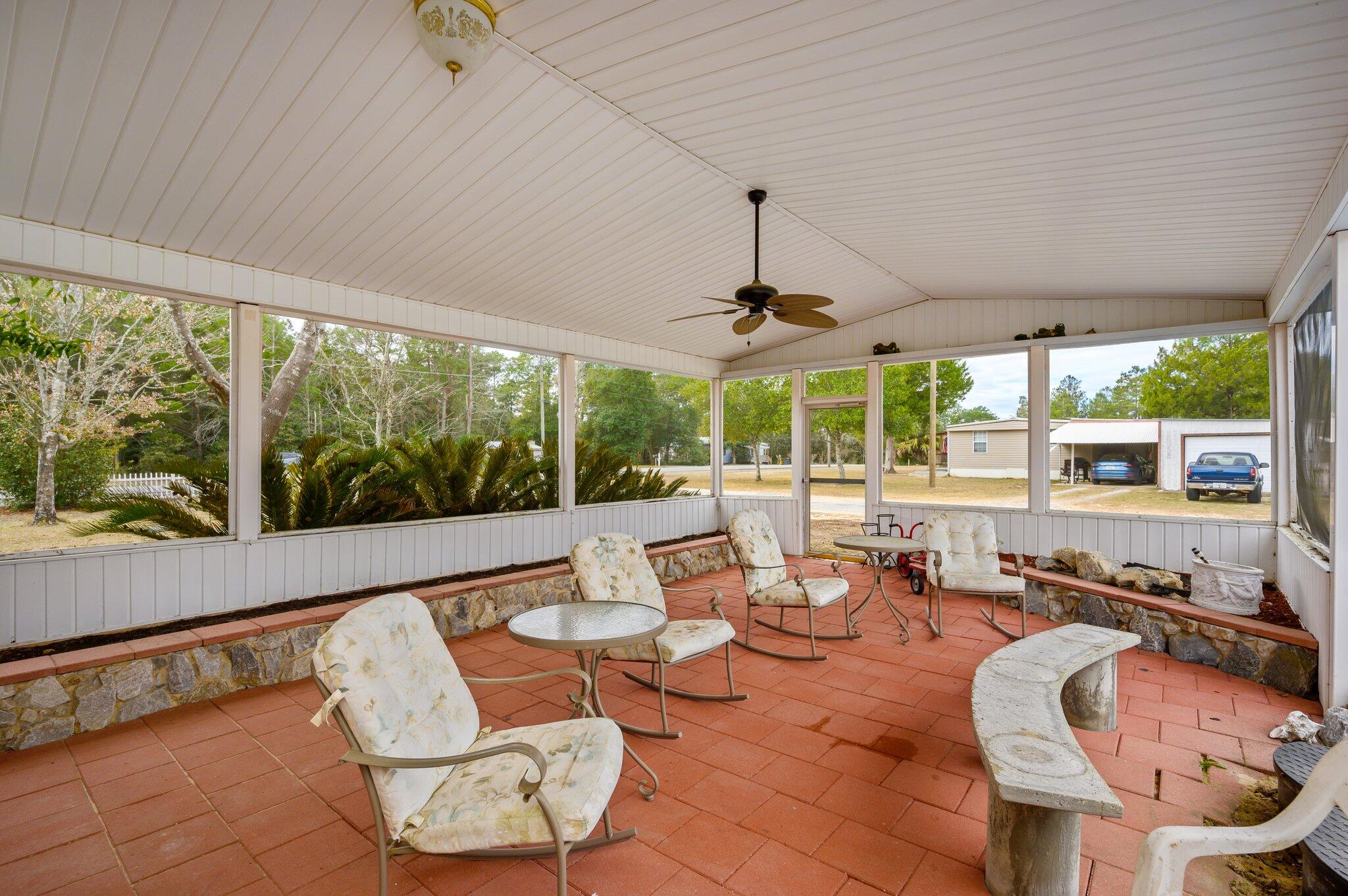 52 Tulip Avenue DeFuniak Springs, FL 32433 - Photo 30 of 34 a living room with patio furniture and a chandelier