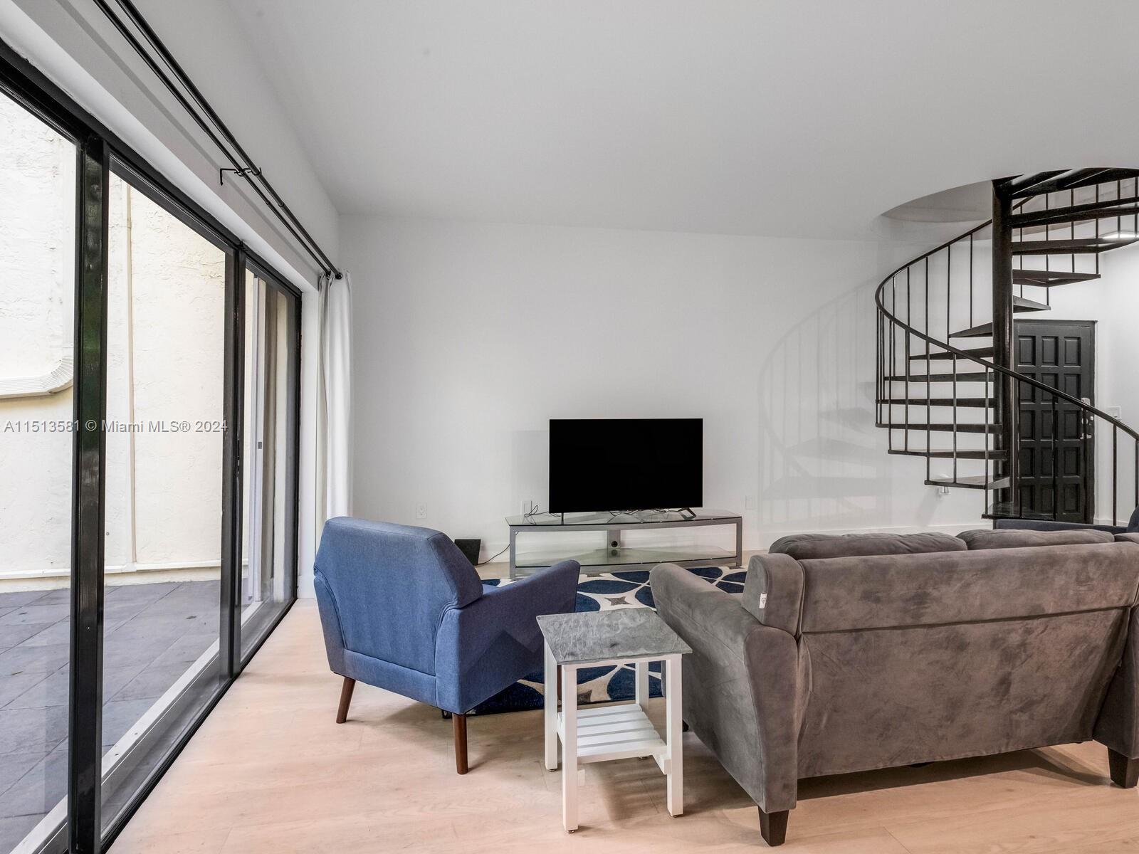 2430 Brickell Avenue, Unit 105A Miami, FL 33129 - Photo 11 of 27 a living room with furniture and a flat screen tv