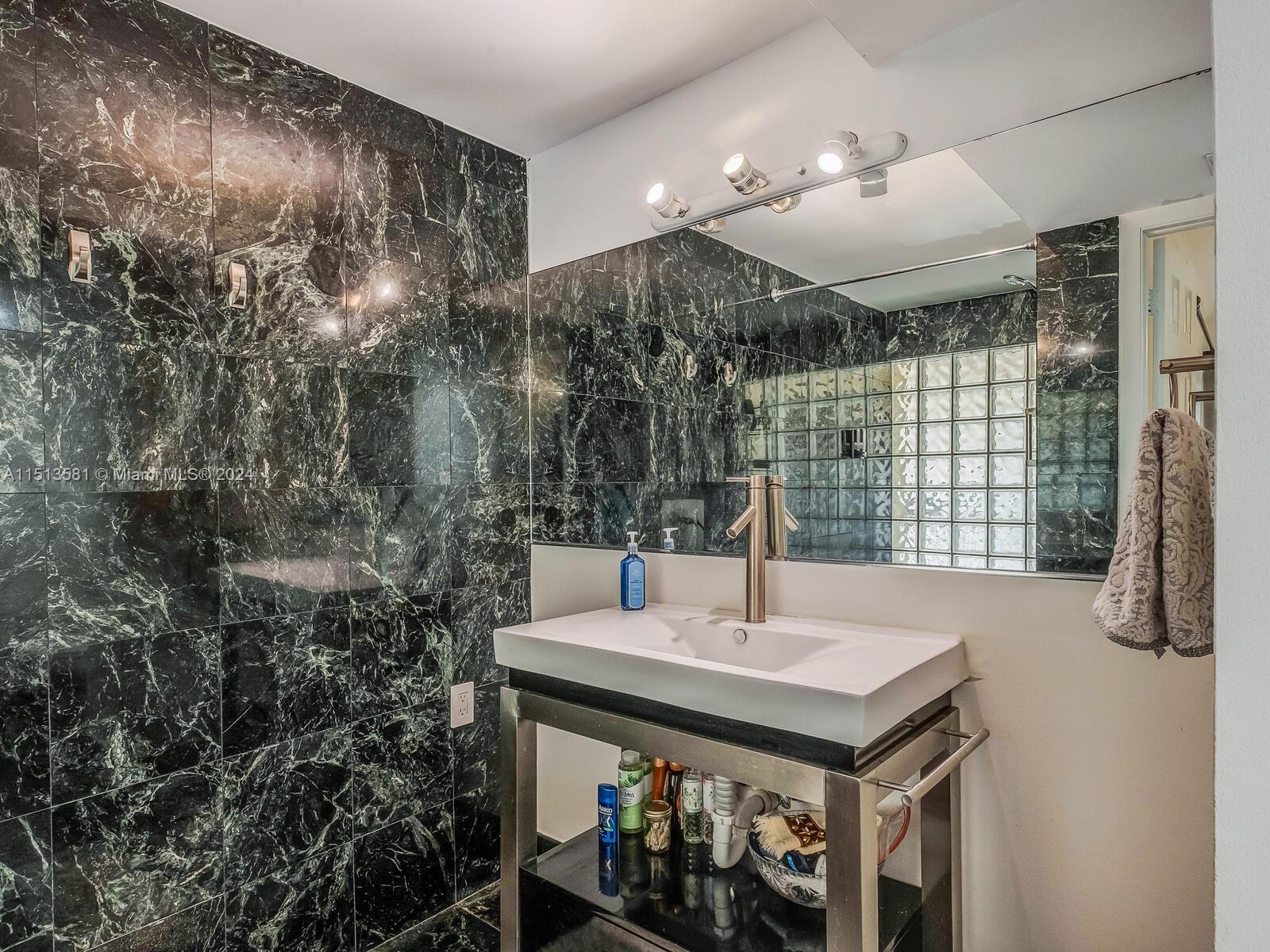 2430 Brickell Avenue, Unit 105A Miami, FL 33129 - Photo 16 of 27 a bathroom with a sink and a mirror