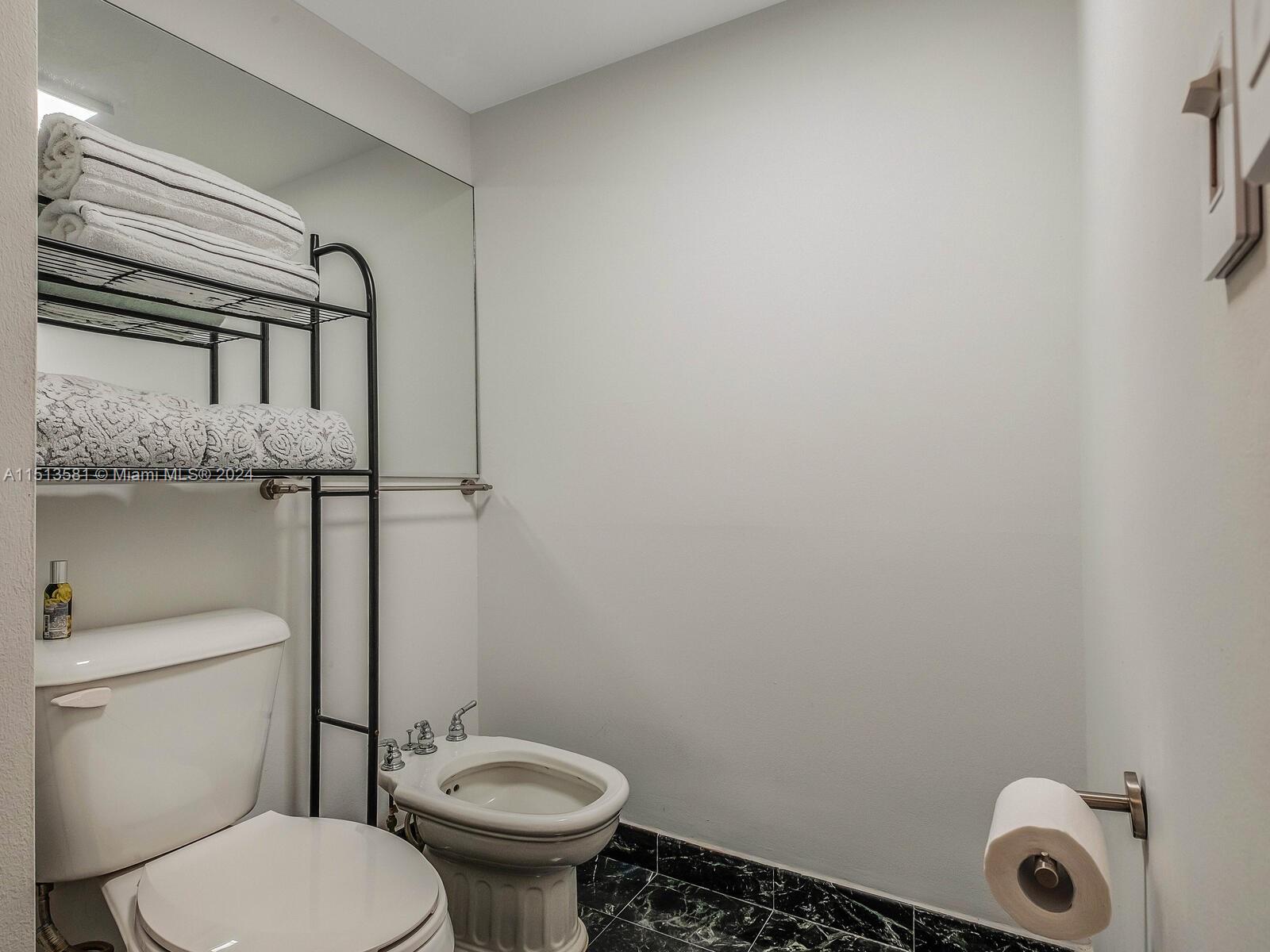 2430 Brickell Avenue, Unit 105A Miami, FL 33129 - Photo 17 of 27 a white toilet sitting next to a shower curtain