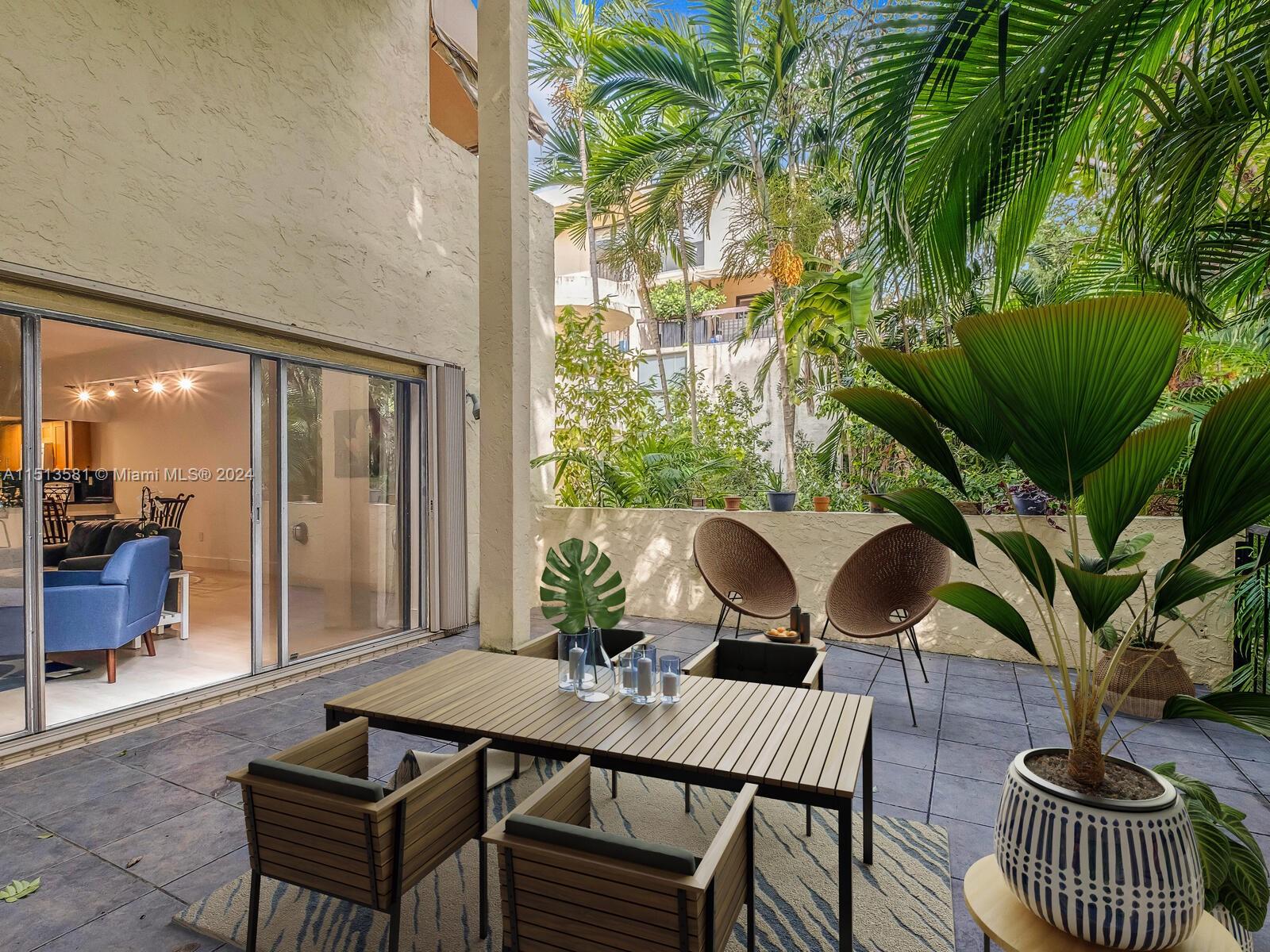 2430 Brickell Avenue, Unit 105A Miami, FL 33129 - Photo 8 of 27 a view of a patio with couple of chairs and a potted plant