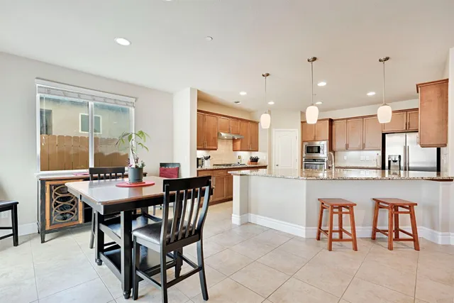 a room with stainless steel appliances kitchen island granite countertop furniture and a view of kitchen