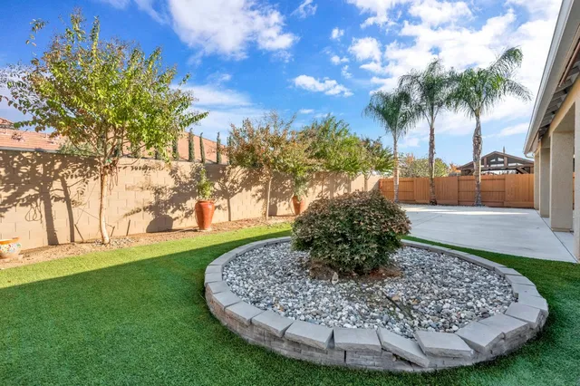 a backyard of a house with plants and outdoor seating