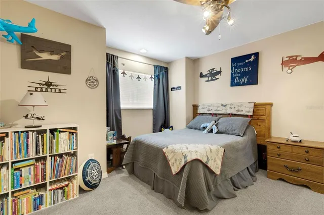 a bedroom with a bed a book shelf and a window