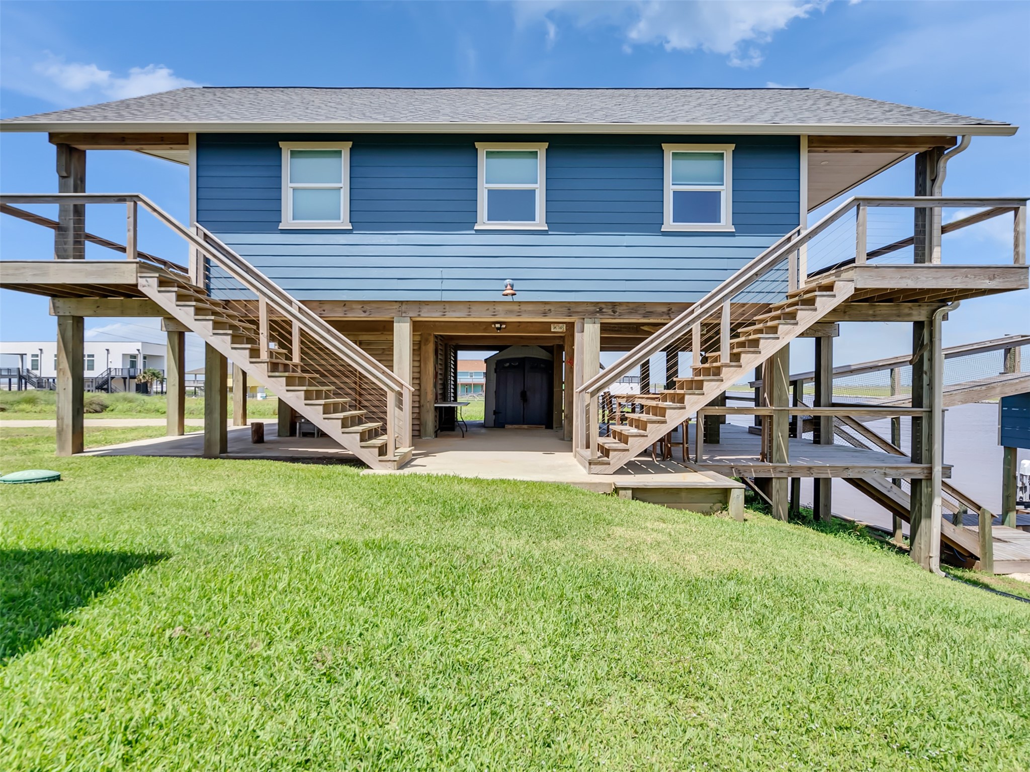 1453 County Road 230 Sargent, TX 77414 - Photo 30 of 38 Waterfront Home — Thoughtfully designed with a grand double-stairway entrance and easy access to expansive upper-level decks, creating a welcoming gateway to waterfront living.