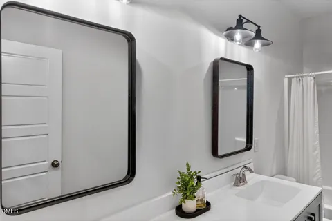 a view of an empty room with wooden floor and a ceiling fan