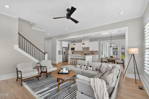 a kitchen with stainless steel appliances kitchen island granite countertop a table chairs stove and white cabinets