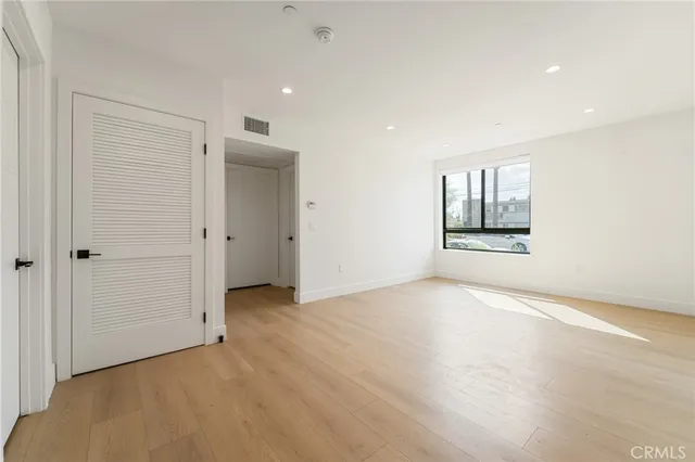 an empty room with windows and closet