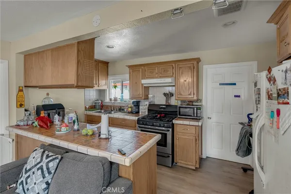a kitchen with lots of clutter and stainless steel appliances