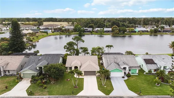 an aerial view of house with yard space and lake view in back