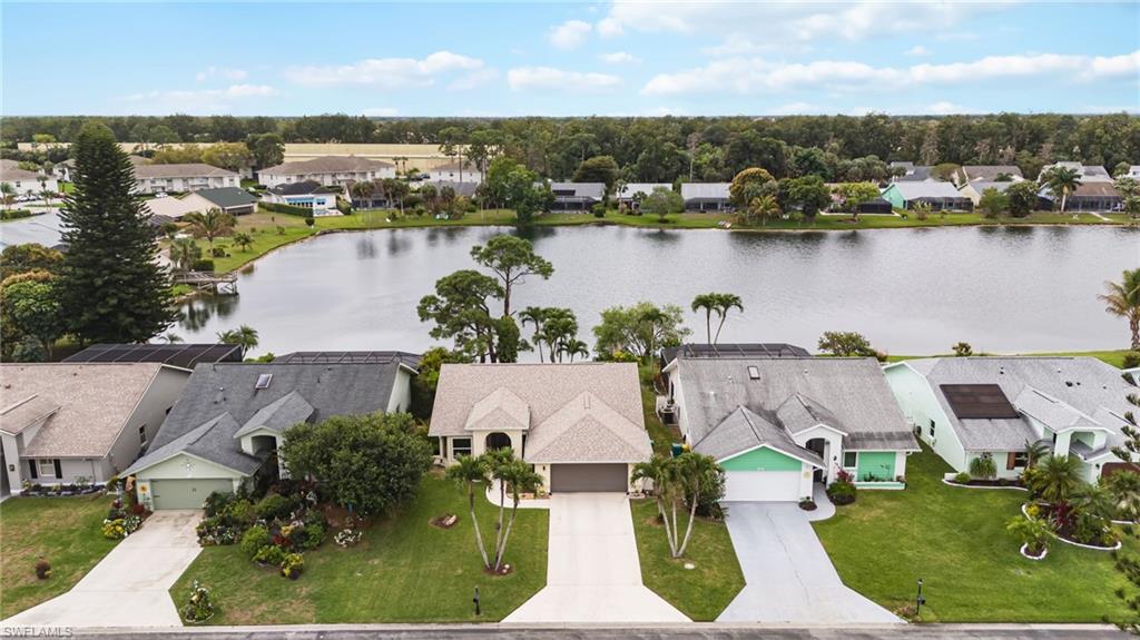 an aerial view of house with yard space and lake view in back