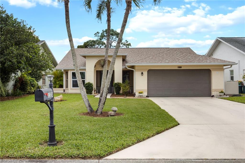 1324 Monarch Circle Naples, FL 34116 - Photo 23 of 23 a front view of a house with garden