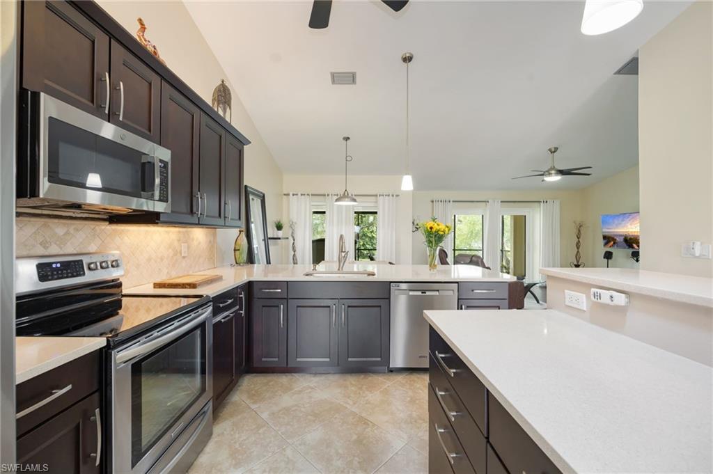 1324 Monarch Circle Naples, FL 34116 - Photo 3 of 23 a kitchen with stainless steel appliances granite countertop a sink and stove top oven