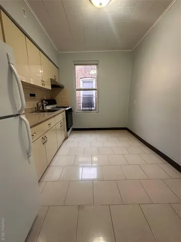 a kitchen with granite countertop a stove a sink and a window