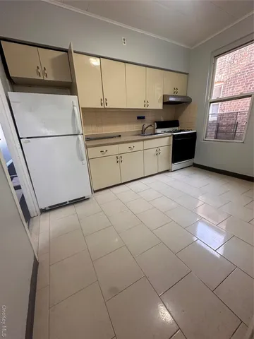 a kitchen with stainless steel appliances granite countertop a sink stove refrigerator and cabinets