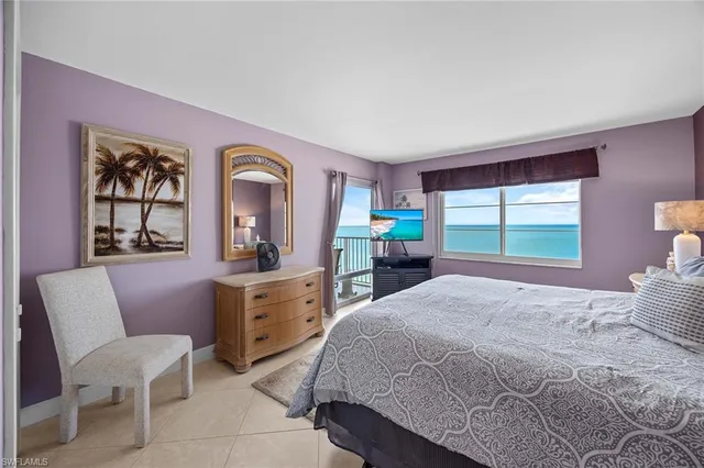 a bedroom with a large bed and windows