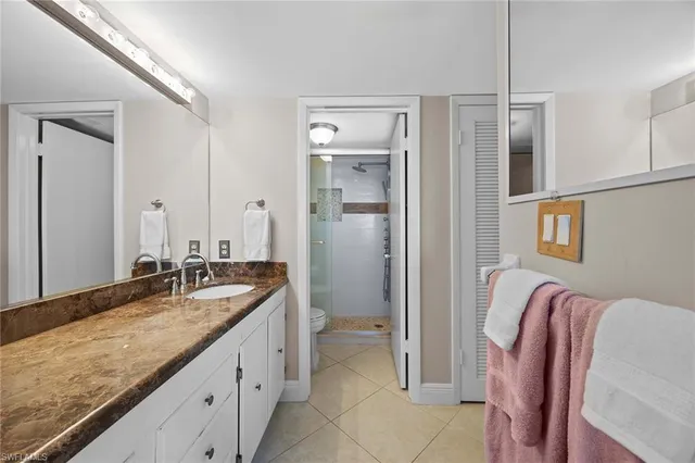 a spacious bathroom with a granite countertop sink and a mirror