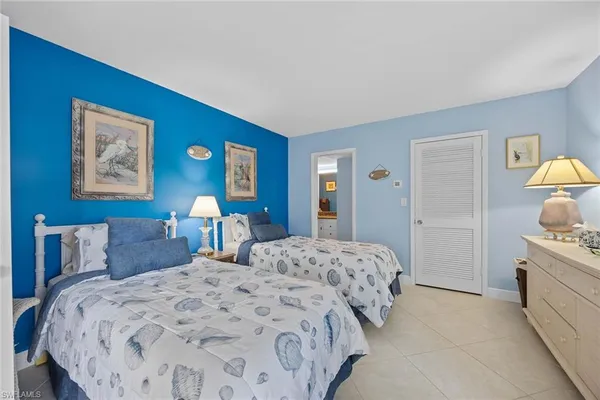 a bedroom with a bed and a lamp on dresser