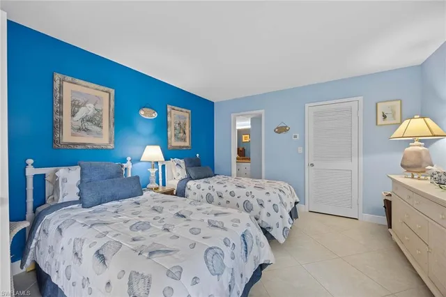 a bedroom with a bed and a lamp on dresser