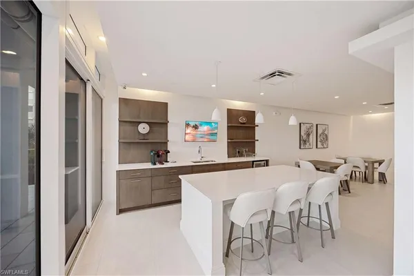 a kitchen with stainless steel appliances a table and chairs in it