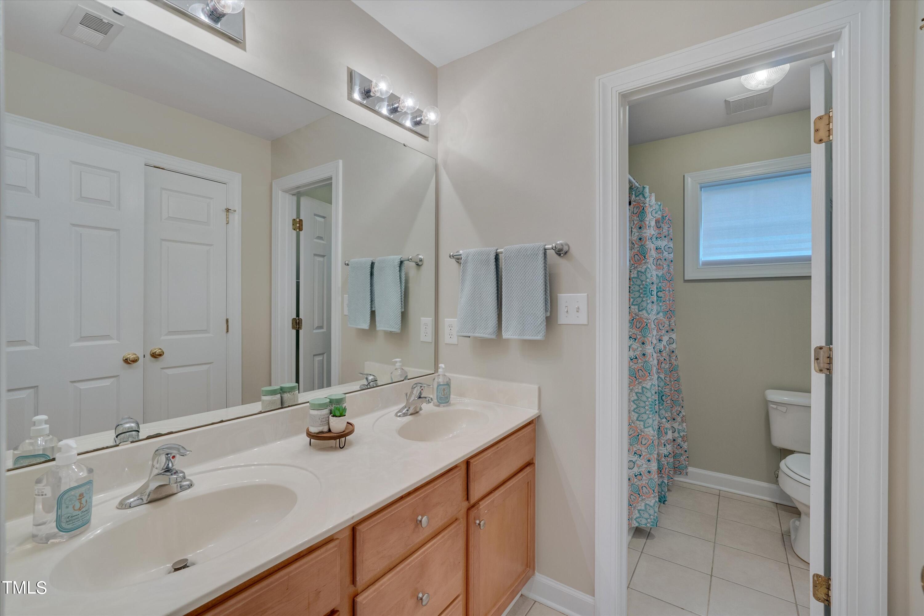 518 Panthers Run Drive Durham, NC 27713 - Photo 32 of 39 a bathroom with a sink double vanity and a mirror