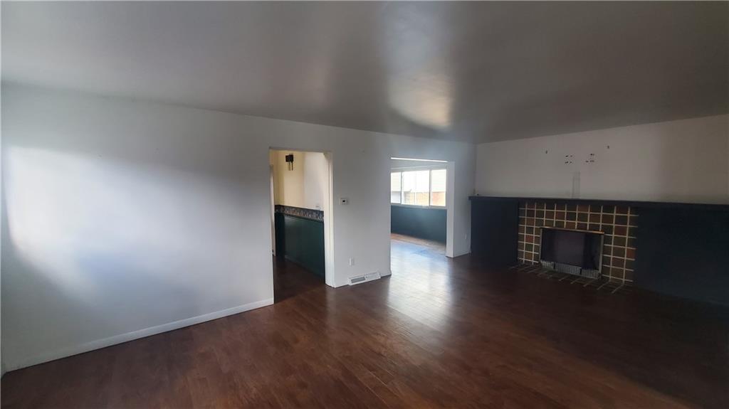 936 Ormond Street Brackenridge, PA 15014 - Photo 11 of 24 an empty room with wooden floor fireplace and windows