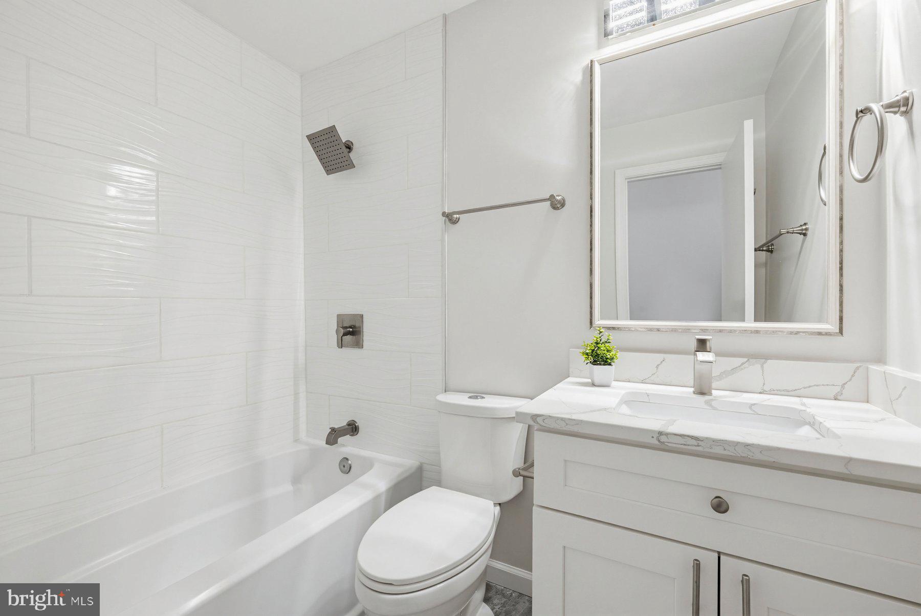 7305 Langsford Court Springfield, VA 22153 - Photo 27 of 46 a bathroom with a granite countertop sink toilet a large mirror a shower and a bathtub