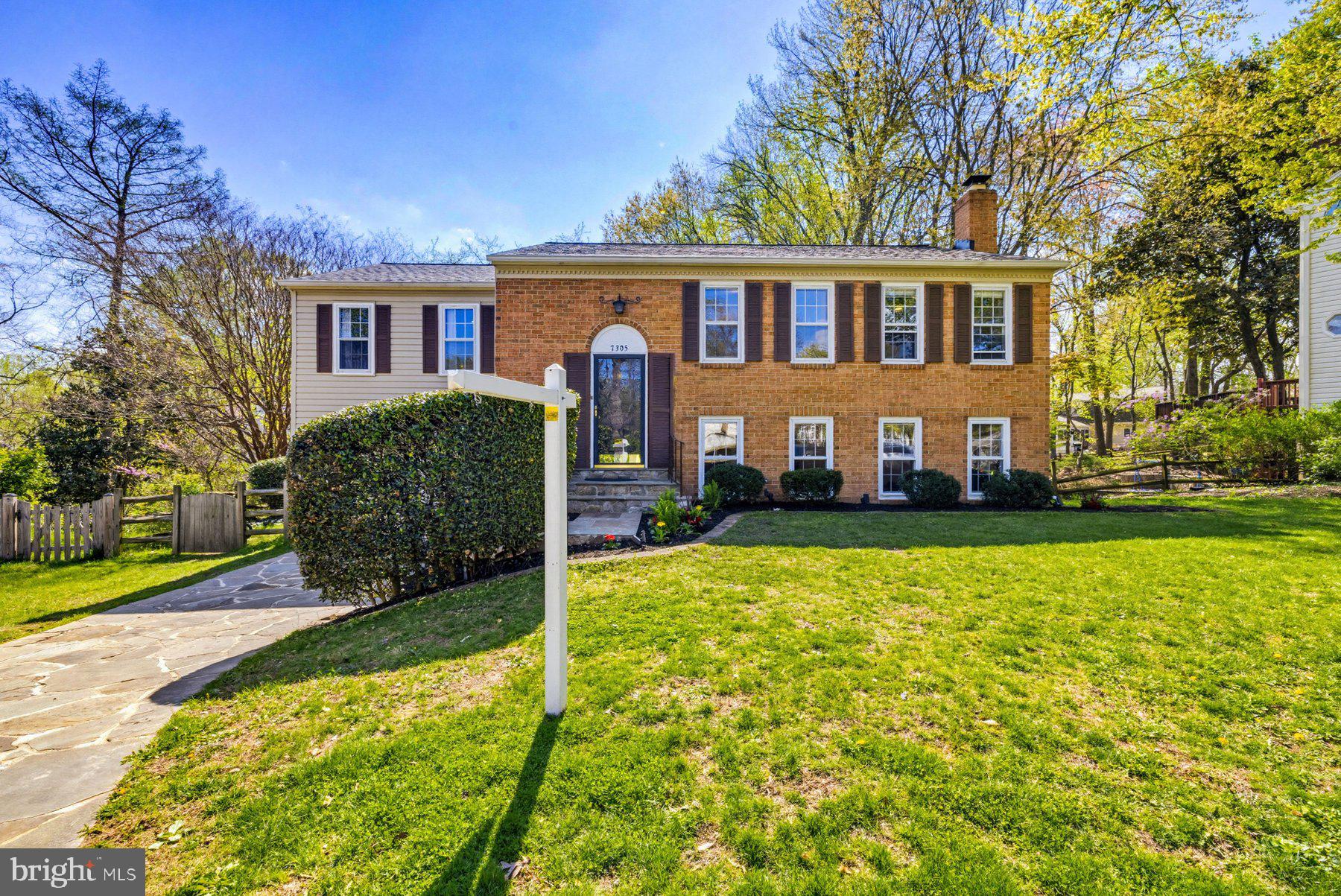 7305 Langsford Court Springfield, VA 22153 - Photo 3 of 46 a front view of a house with a yard table and seating