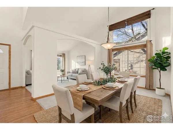 a dining room with furniture large windows and wooden floor