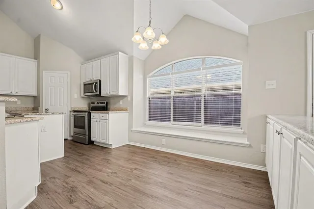 a kitchen with a refrigerator stove top oven and sink