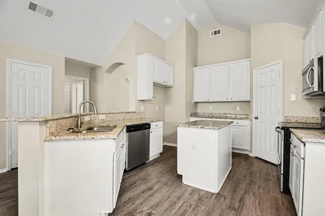 a kitchen with a sink stove and cabinets