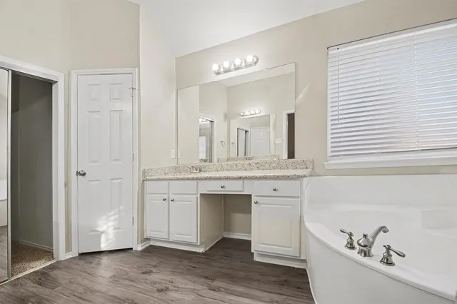a spacious bathroom with a bathtub sink and mirror