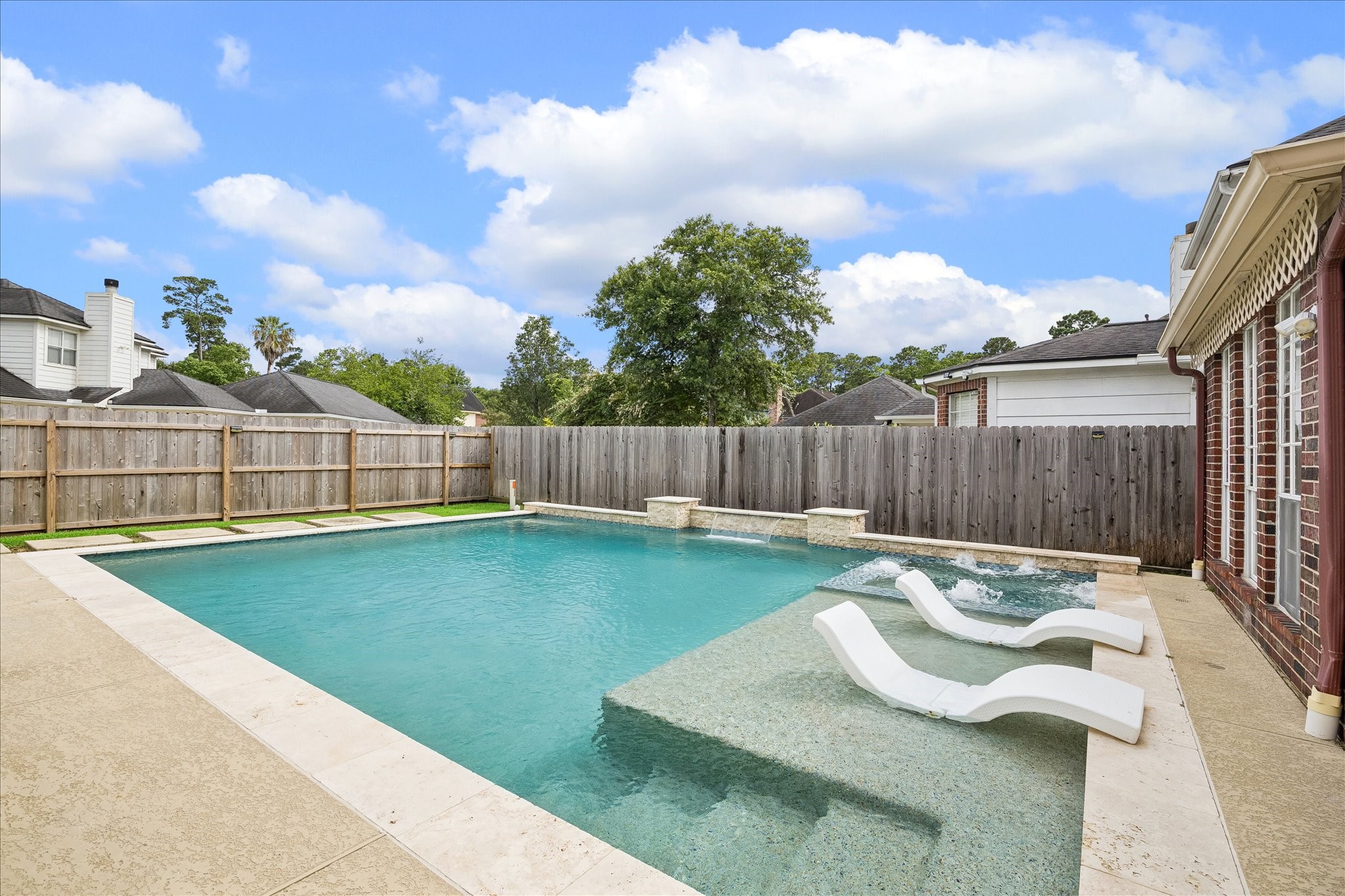 7915 Huddersfield Court Spring, TX 77379 - Photo 36 of 37 Resort-style backyard with a sparkling pool, sun deck, water features, and patio space designed for relaxing and entertaining.
