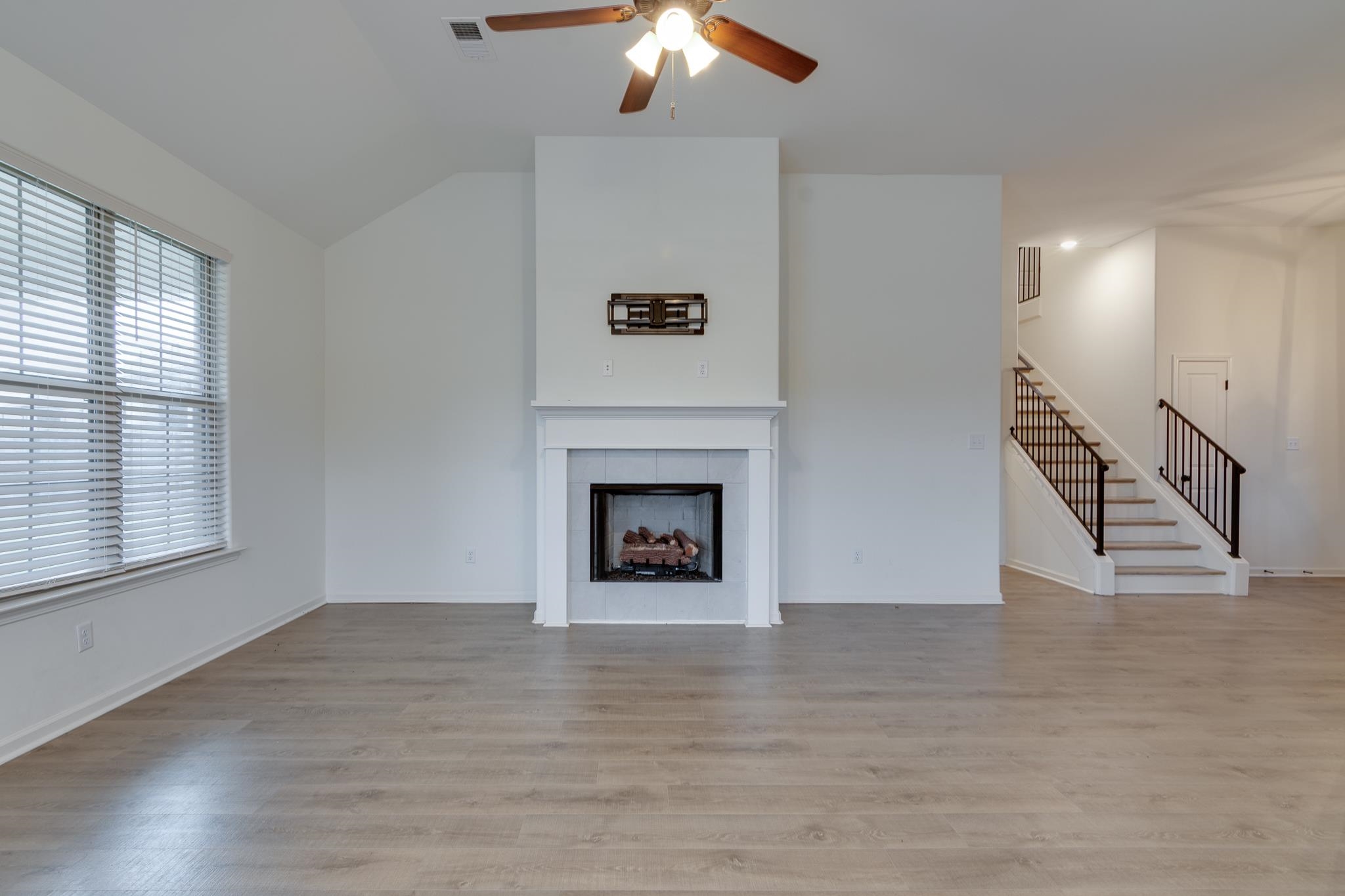 155 Misty Ridge Loop Oakland, TN 38060 - Photo 4 of 26 a view of an empty room with wooden floor fireplace and a window