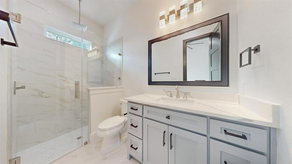 1860 Old Telico Road Ennis, TX 75119 - Photo 15 of 40 a bathroom with a toilet a sink a mirror and a shower