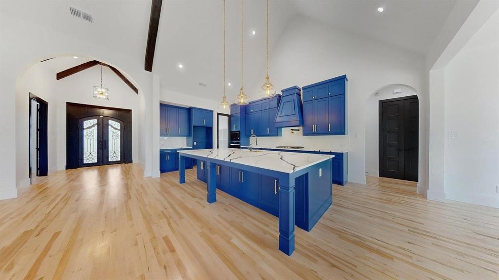 1860 Old Telico Road Ennis, TX 75119 - Photo 4 of 40 a kitchen with stainless steel appliances kitchen island granite countertop wooden floors and a sink