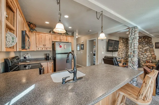 a kitchen with stainless steel appliances granite countertop a sink dishwasher and a stove with wooden floor