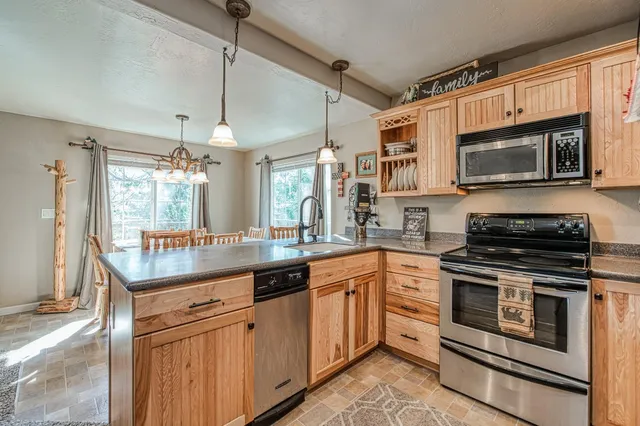 a kitchen with stainless steel appliances granite countertop a stove microwave and sink