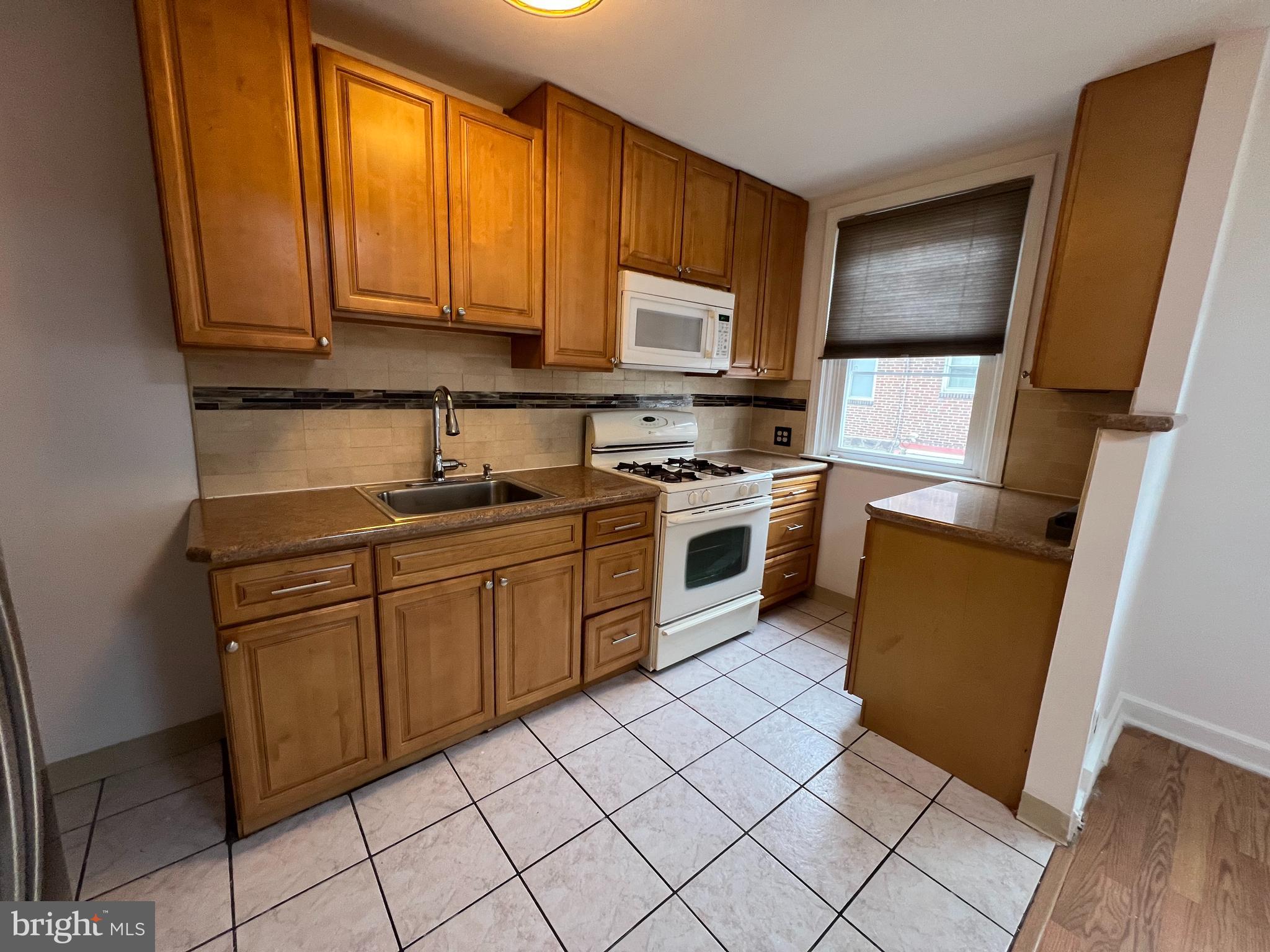 4312 Loring Street Philadelphia, PA 19136 - Photo 4 of 14 a kitchen with stainless steel appliances granite countertop wooden cabinets a stove top oven a sink and dishwasher