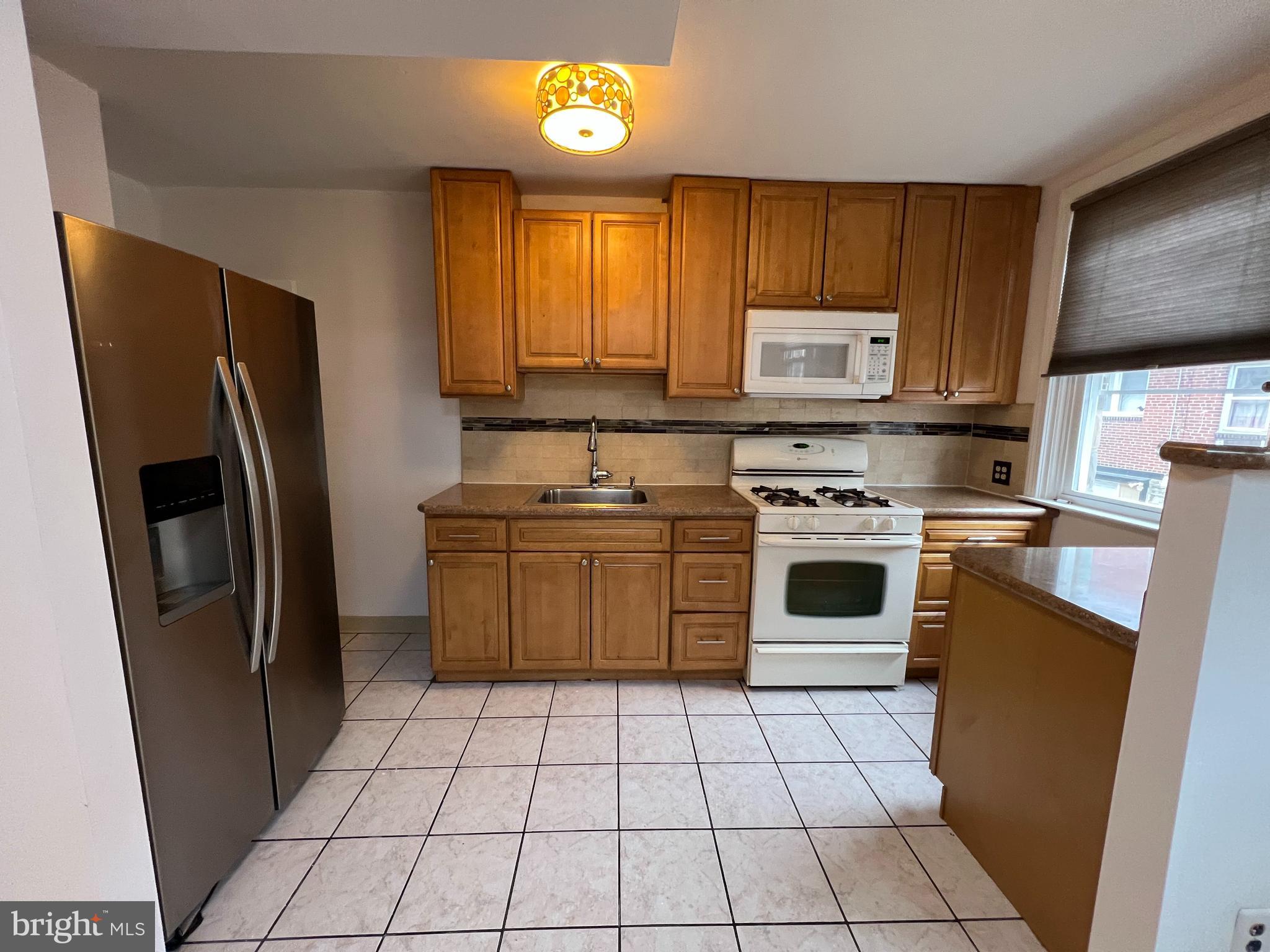 4312 Loring Street Philadelphia, PA 19136 - Photo 5 of 14 a kitchen with a stove a refrigerator and a sink