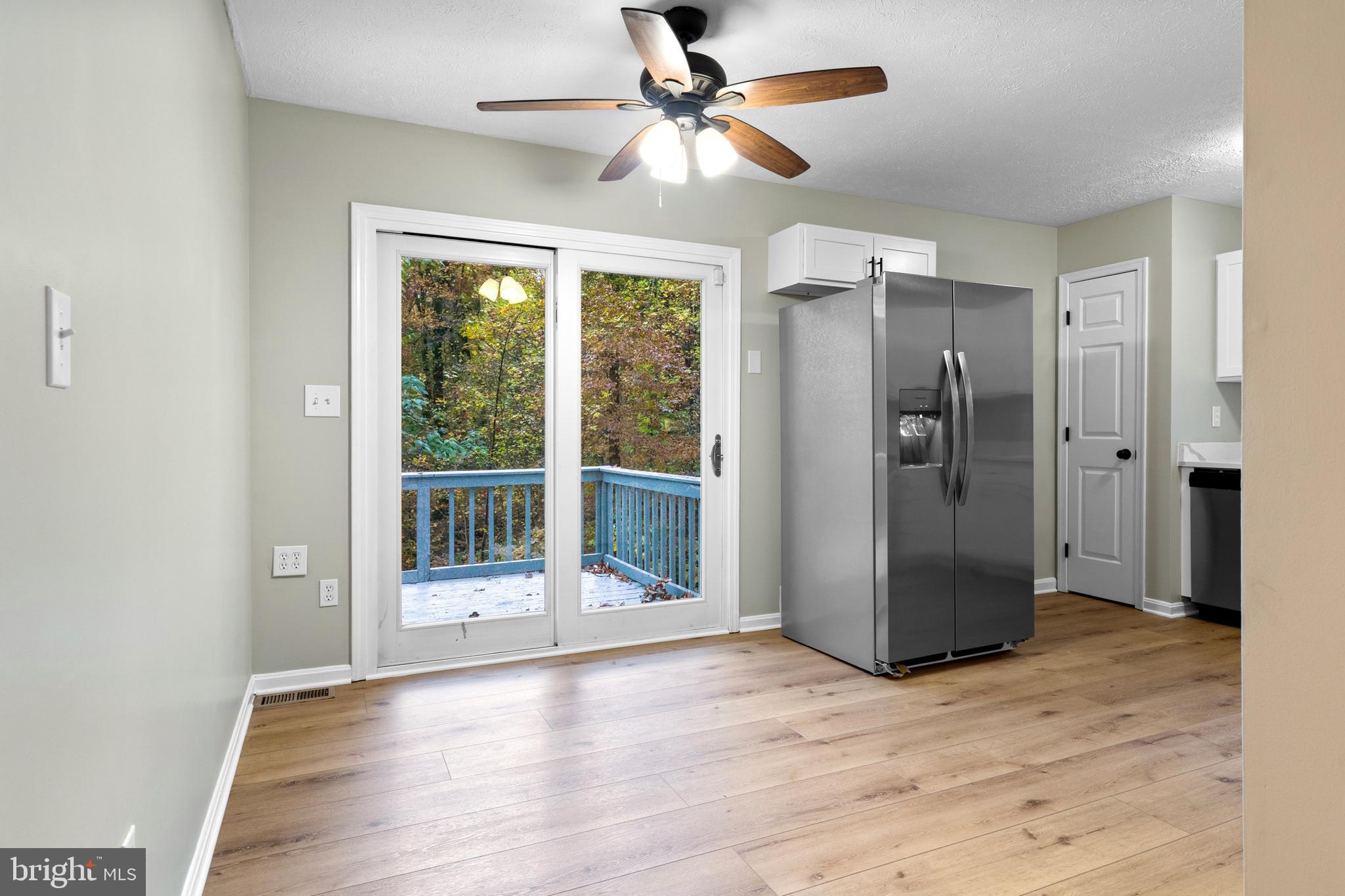369 Wild Hare Road Harpers Ferry, WV 25425 - Photo 11 of 29 a view of a glass door with wooden floor and a ceiling fan