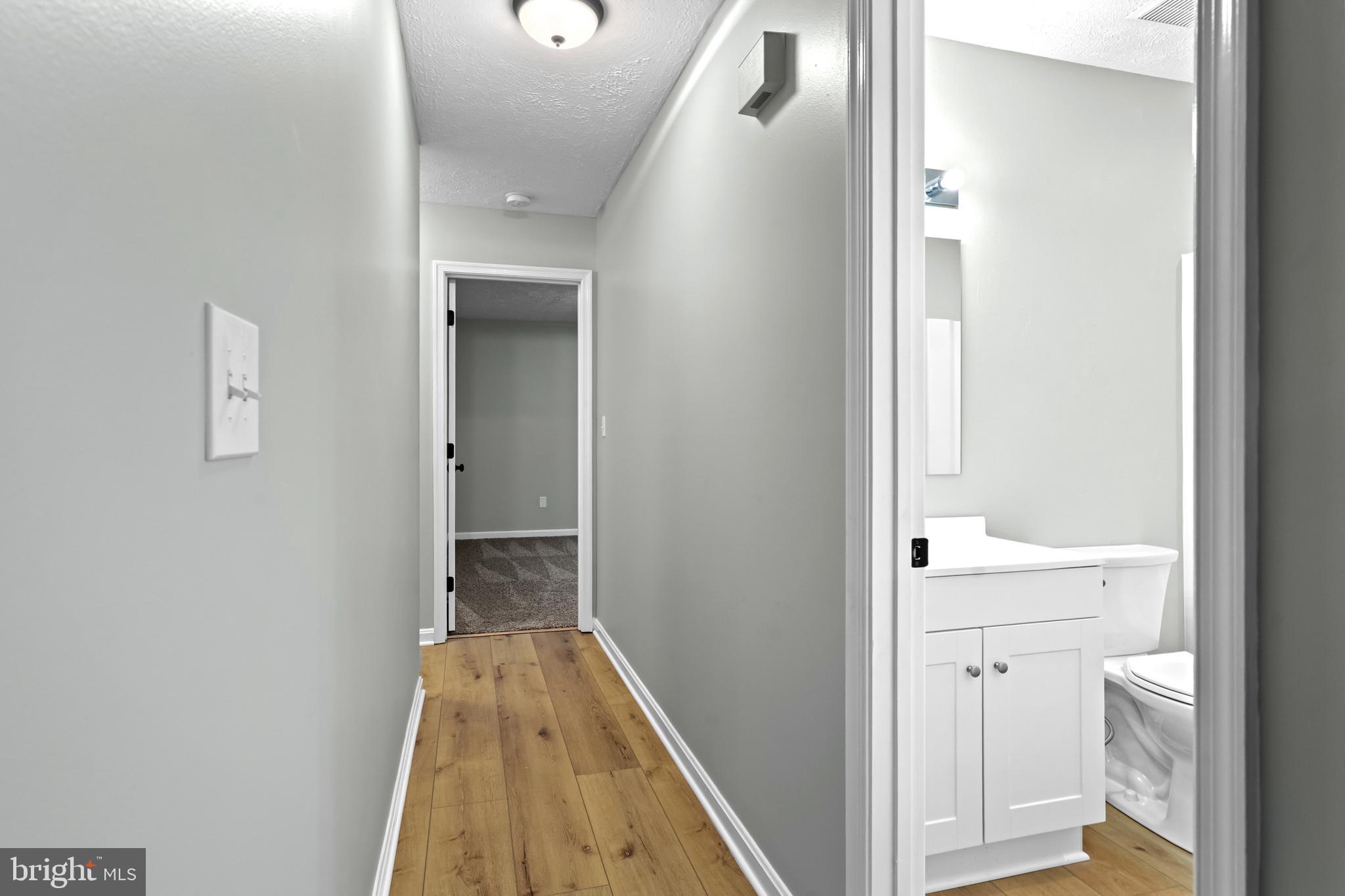 369 Wild Hare Road Harpers Ferry, WV 25425 - Photo 16 of 29 a view of a hallway with wooden floor and a bathroom