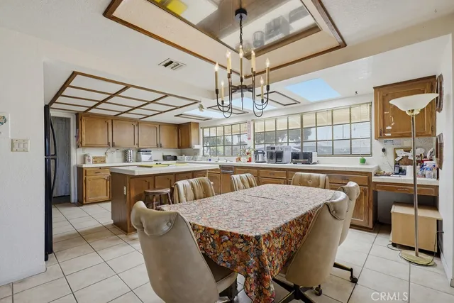 a kitchen with a table chairs microwave and cabinets