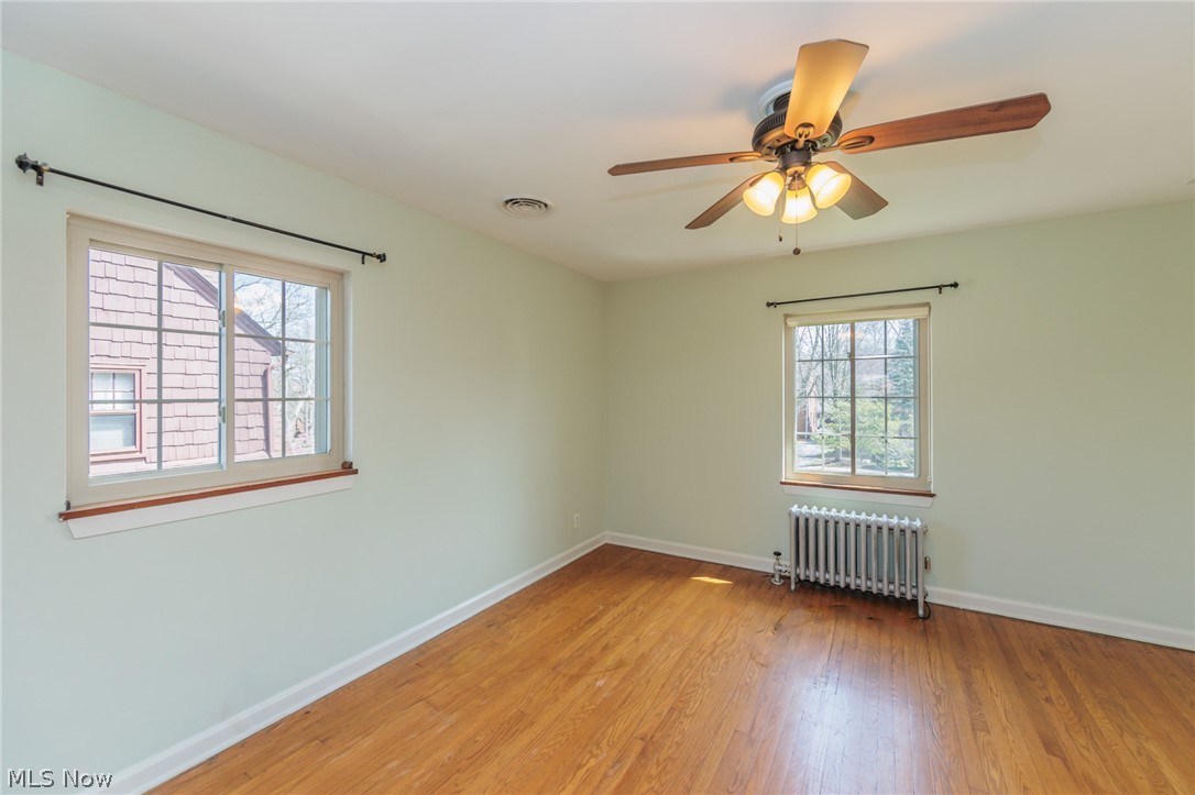 2472 Eaton Road Cleveland, OH 44118 - Photo 28 of 50 Empty room featuring ceiling fan, light hardwood / wood-style flooring, and radiator heating unit