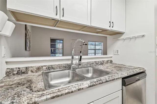 a kitchen with stainless steel appliances granite countertop a stove microwave and sink